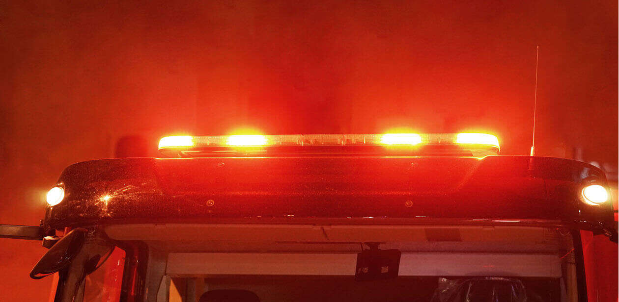 Illuminated red emergency light bar on a fire truck that represents as responding to a night fire in Cincinnati.