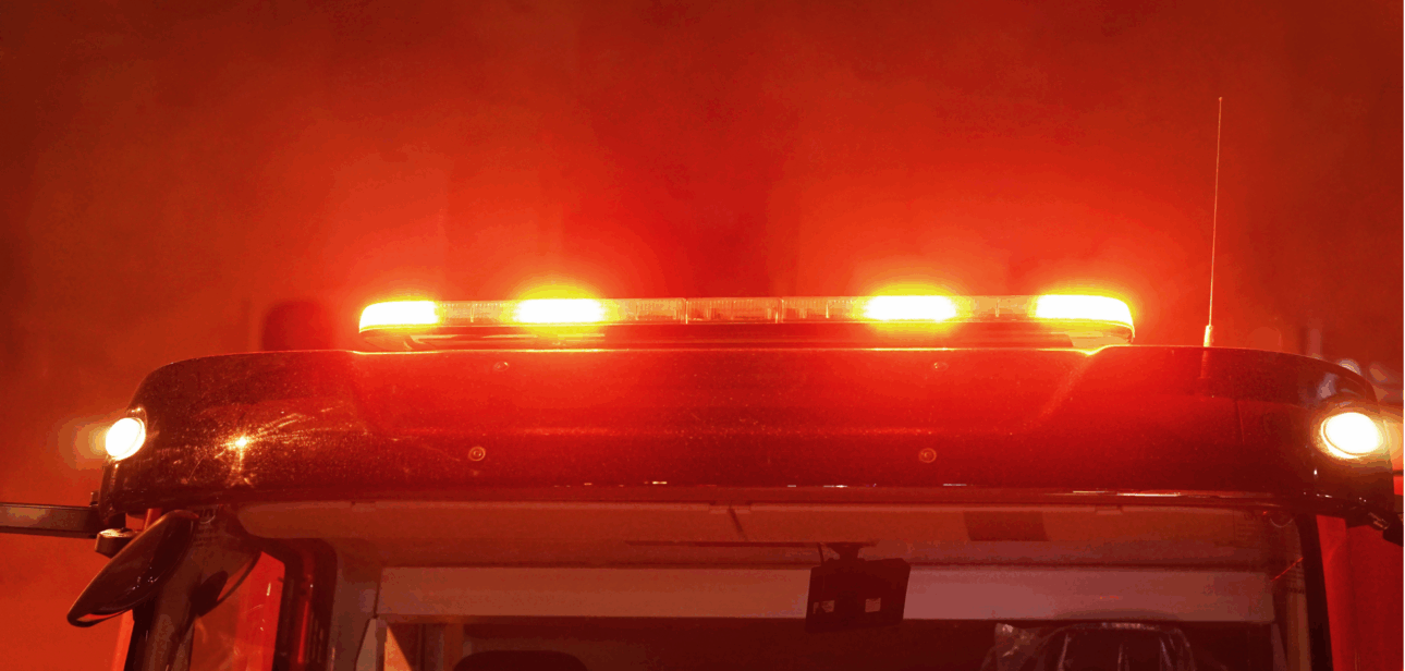 Illuminated red emergency light bar on a fire truck that represents as responding to a night fire in Cincinnati.