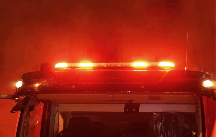 Illuminated red emergency light bar on a fire truck that represents as responding to a night fire in Cincinnati.