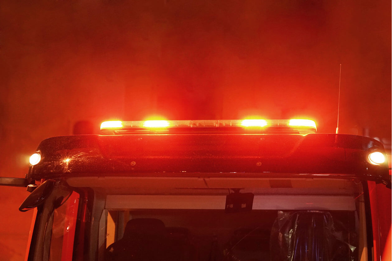 Illuminated red emergency light bar on a fire truck that represents as responding to a night fire in Cincinnati.