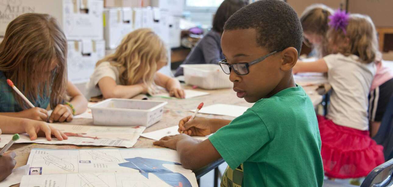 Elementary students working in a Cincinnati classroom, illustrating how administrative staff growth impacts instructional time and student support.