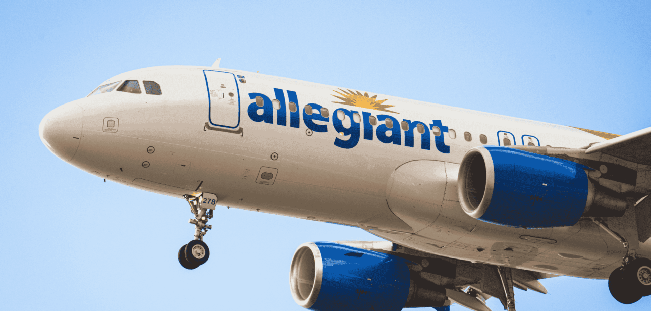 Commercial Allegiant Air airplane flying against a clear blue sky.