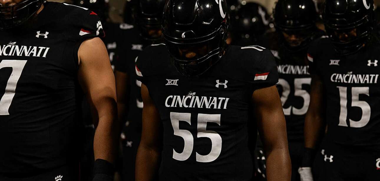 Cincinnati Bearcats football players walk through the stadium tunnel with their heads down after the Cincinnati vs TCU game.