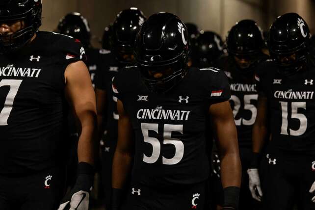 Cincinnati Bearcats football players walk through the stadium tunnel with their heads down after the Cincinnati vs TCU game.
