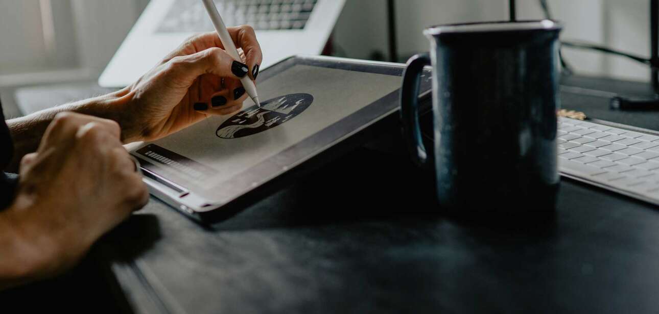 Person sketching design work on a tablet at a desk in a modern studio, representing Cincinnati creative jobs and the changing design industry.