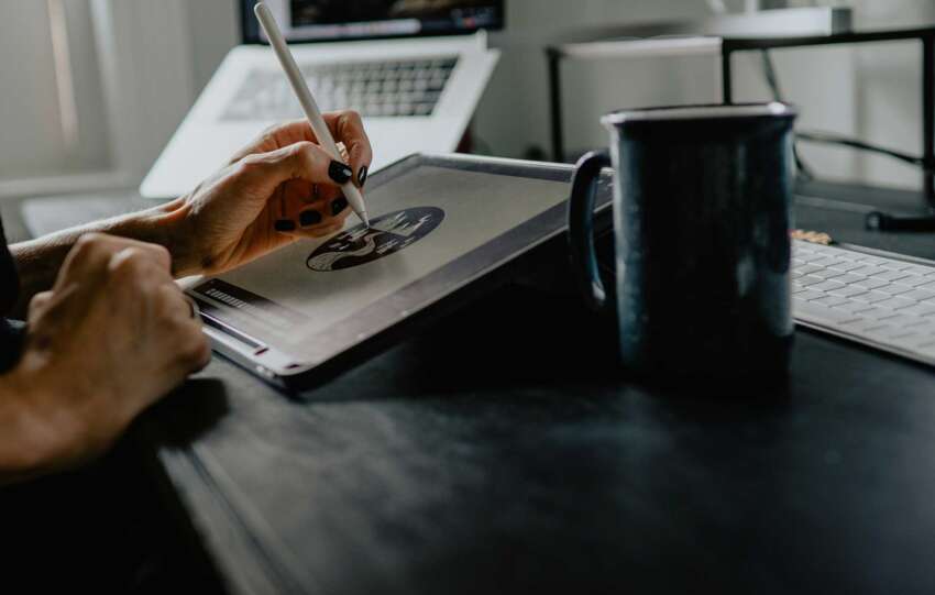 Person sketching design work on a tablet at a desk in a modern studio, representing Cincinnati creative jobs and the changing design industry.
