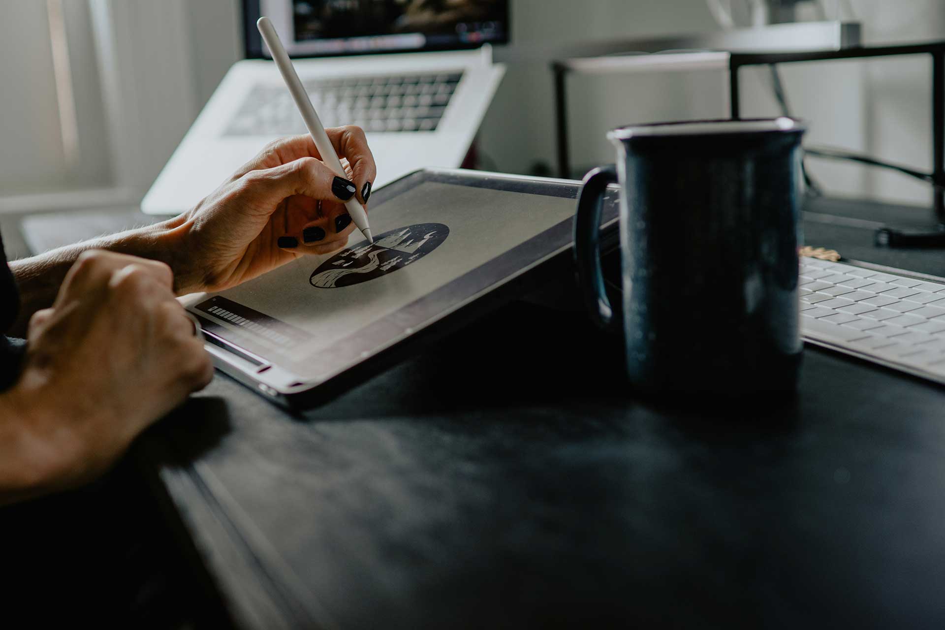 Person sketching design work on a tablet at a desk in a modern studio, representing Cincinnati creative jobs and the changing design industry.