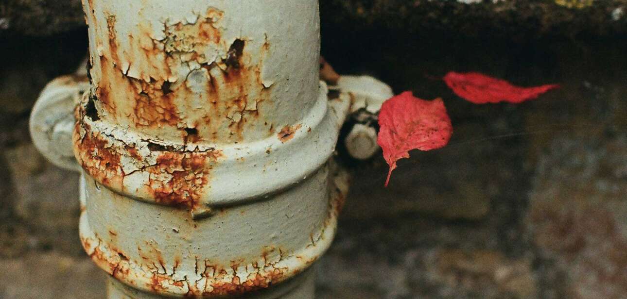 Rusting lead service pipe with visible corrosion near the base, representing aging infrastructure in Cincinnati's water system.