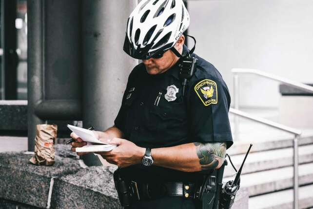 Police officer writing a report in downtown Cincinnati, highlighting Cincinnati public safety concerns