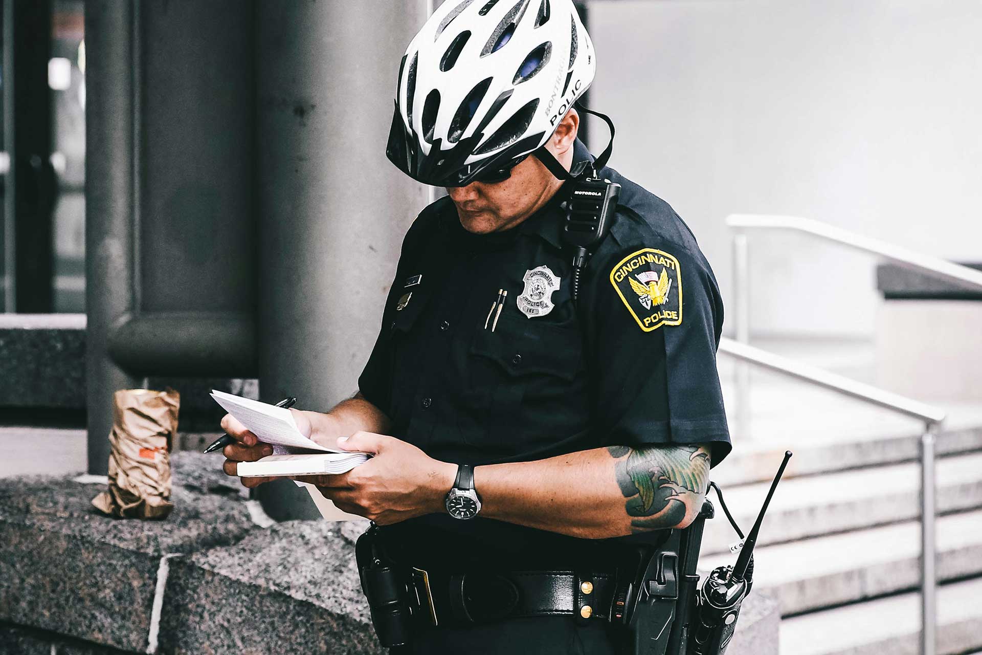 Police officer writing a report in downtown Cincinnati, highlighting Cincinnati public safety concerns