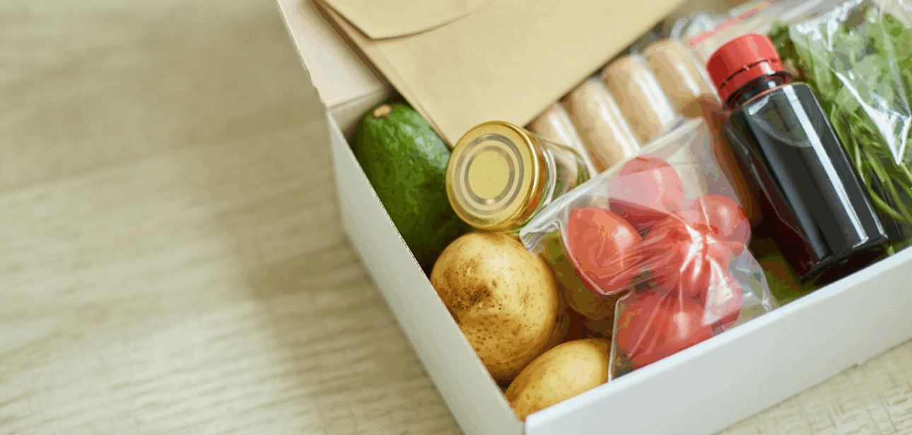 Open Thanksgiving meal kit box filled with fresh potatoes, vegetables, and ingredients for distribution in Greater Cincinnati.