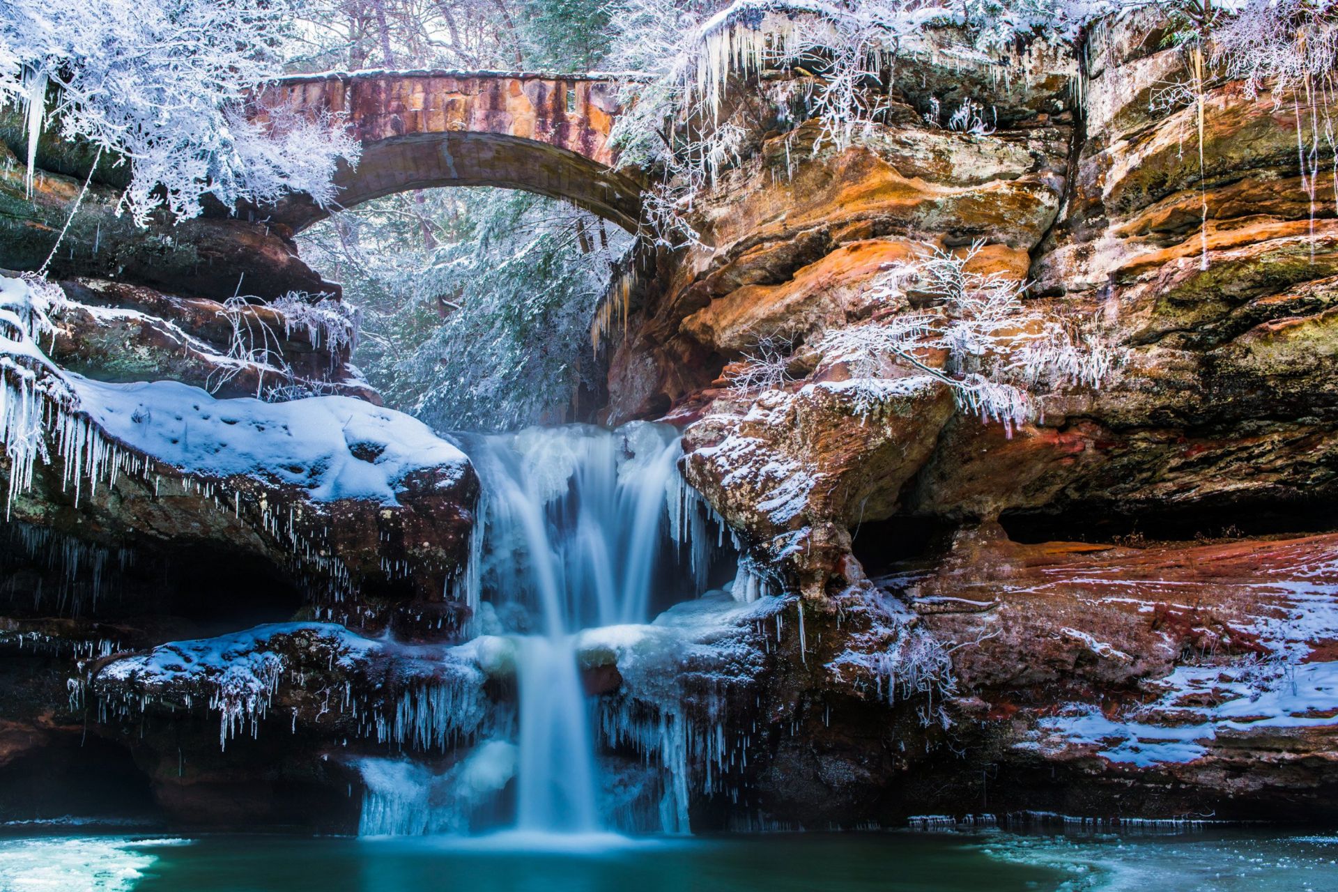 Snow-covered Hocking Hills Cave surrounded by winter forest in Ohio