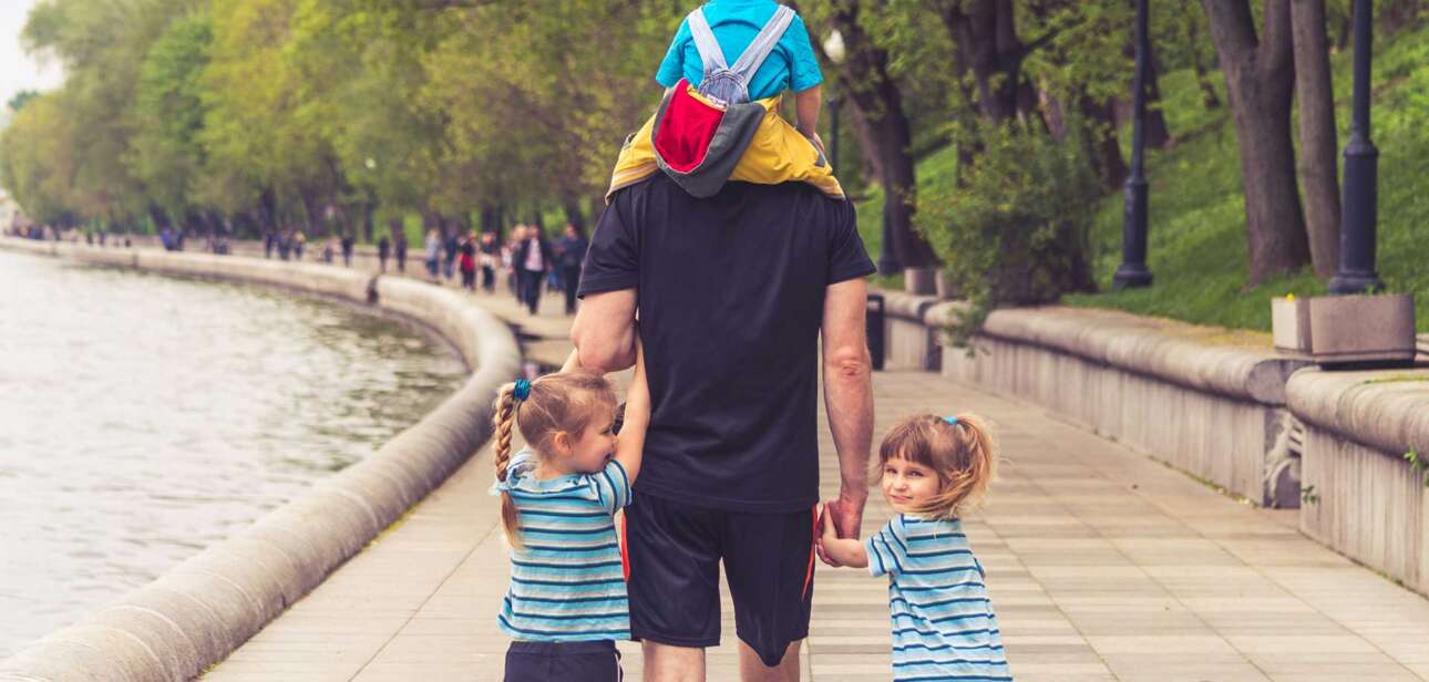 A parent walking with children along a quiet path, representing guidance, reflection, and steady presence in parenting