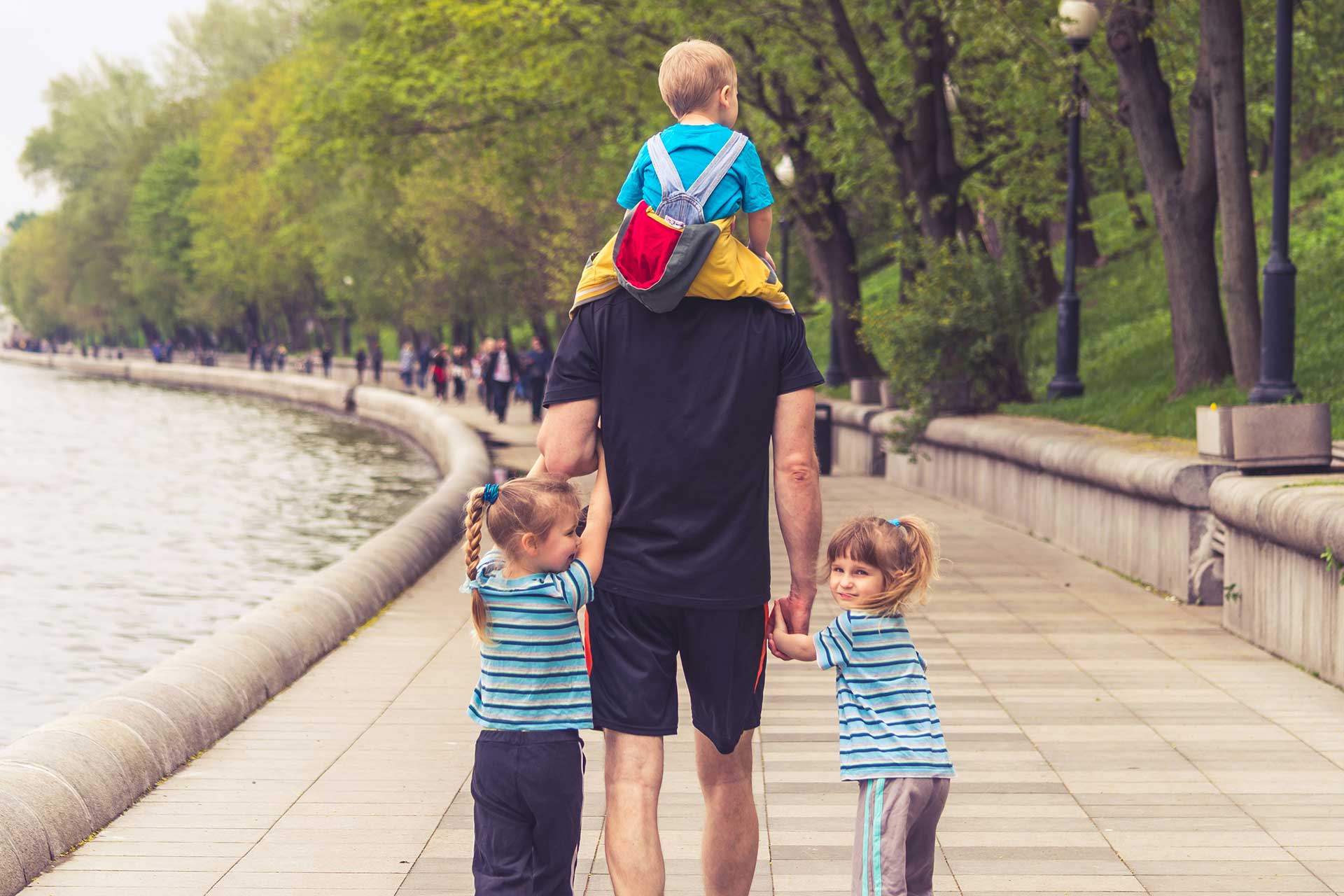 A parent walking with children along a quiet path, representing guidance, reflection, and steady presence in parenting