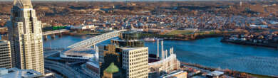 Aerial view of the Cincinnati, Ohio skyline featuring the Roebling Suspension Bridge spanning the Ohio River.