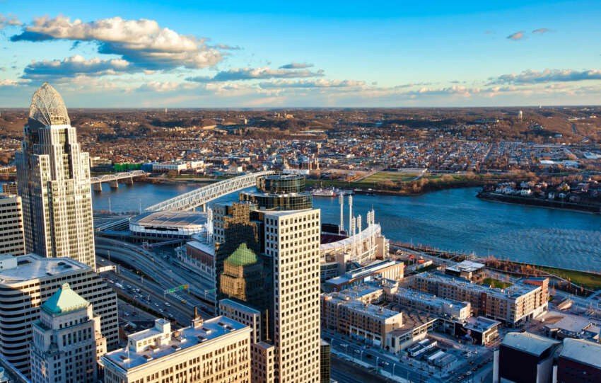 Aerial view of the Cincinnati, Ohio skyline featuring the Roebling Suspension Bridge spanning the Ohio River.