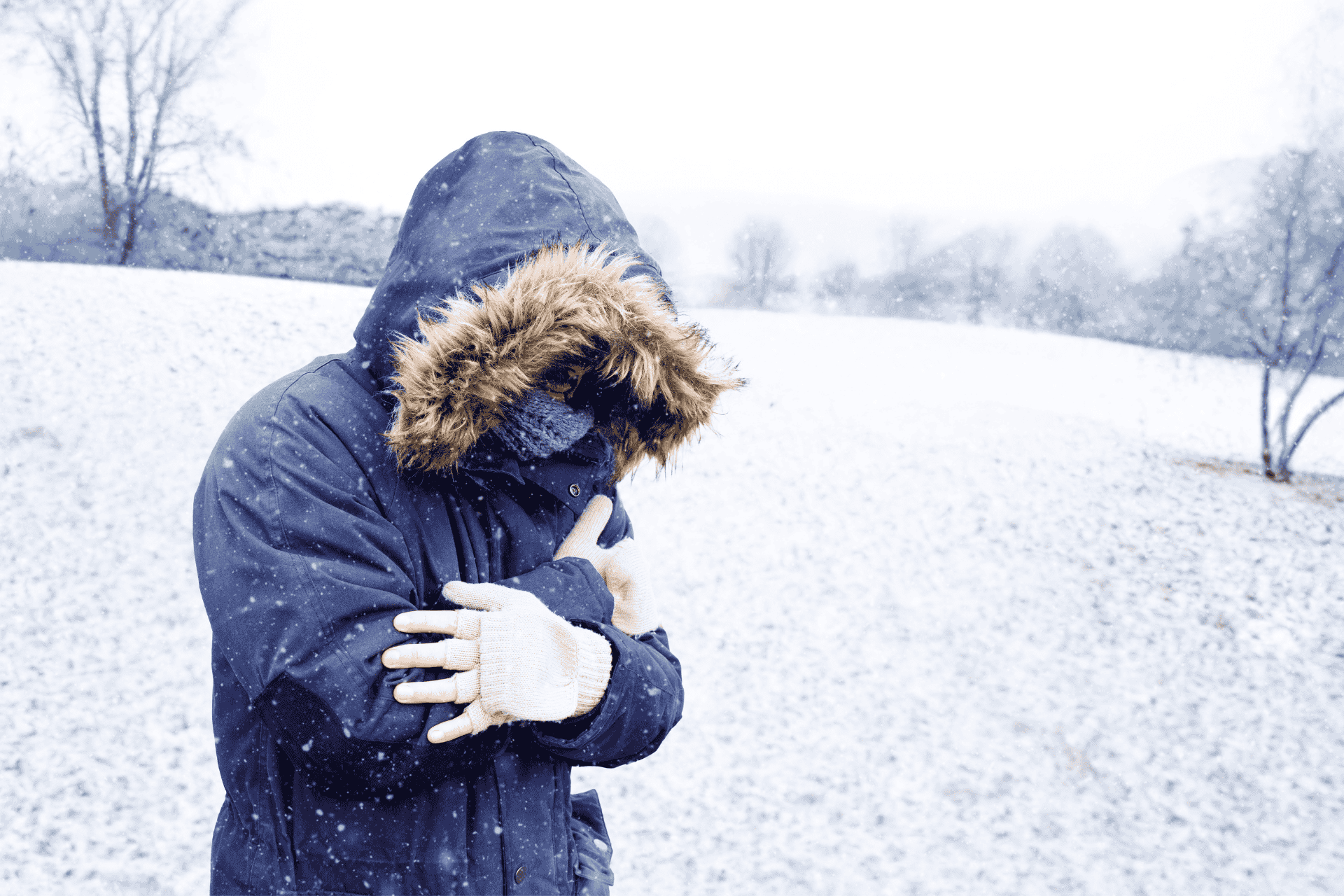 Person that shows bundling up in a heavy winter coat with a fur hood during freezing snowy weather in Cincinnati.