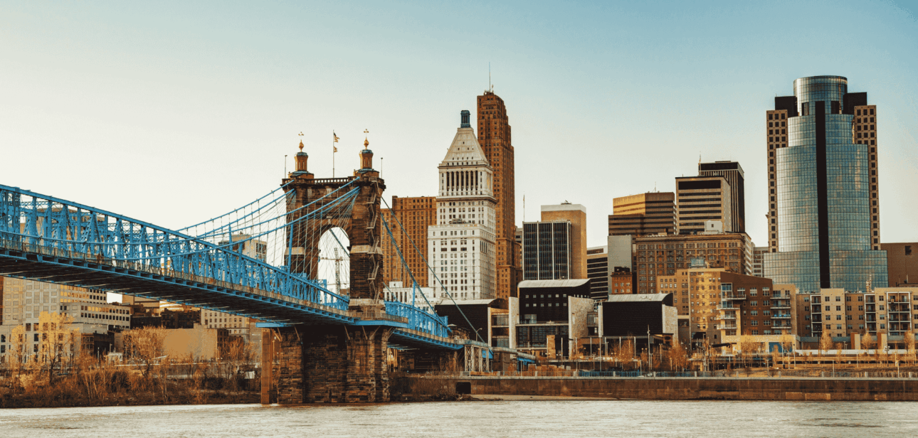 View of the Cincinnati skyline featuring the John A. Roebling Suspension Bridge and the Great American Tower across the Ohio River.