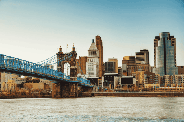 View of the Cincinnati skyline featuring the John A. Roebling Suspension Bridge and the Great American Tower across the Ohio River.