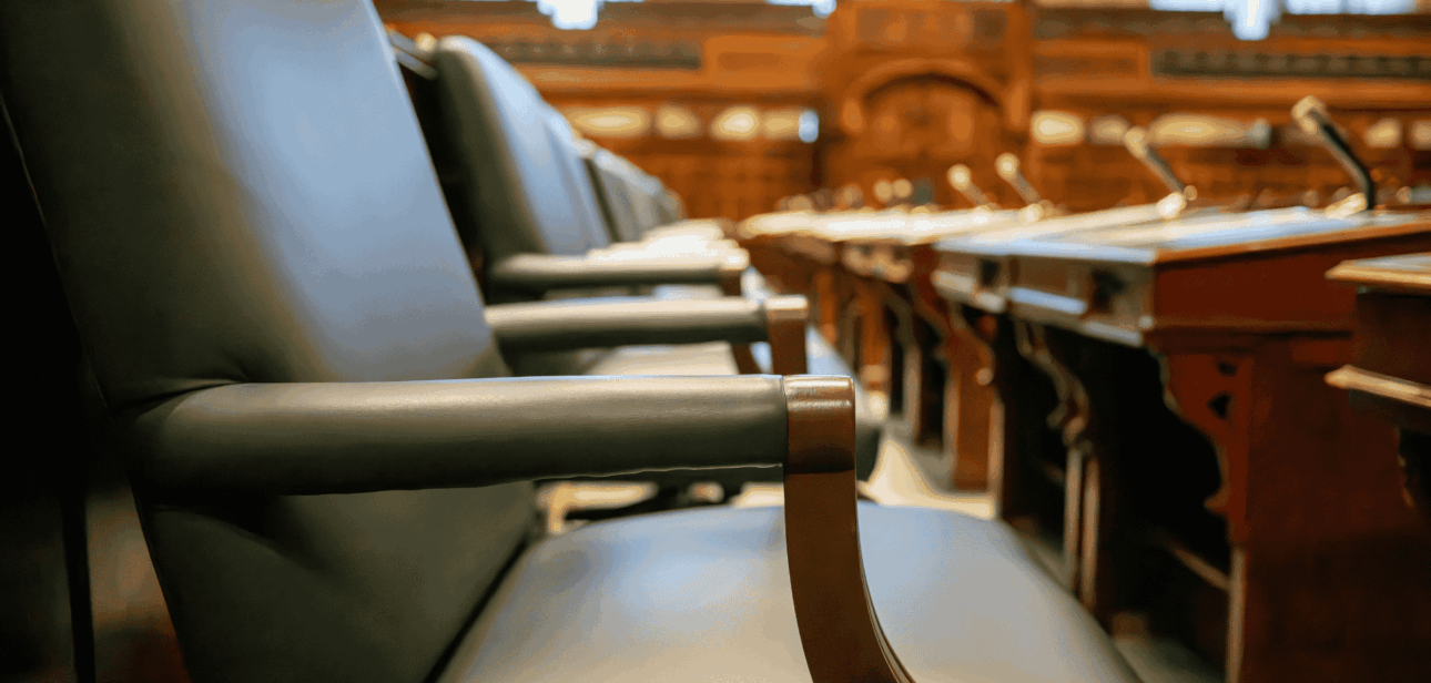 Empty wooden chairs and microphones at the desks illustrating the picture inside the Cincinnati City Council chambers.