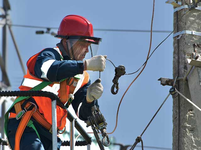 Utility worker performing maintenance to keep power and services running