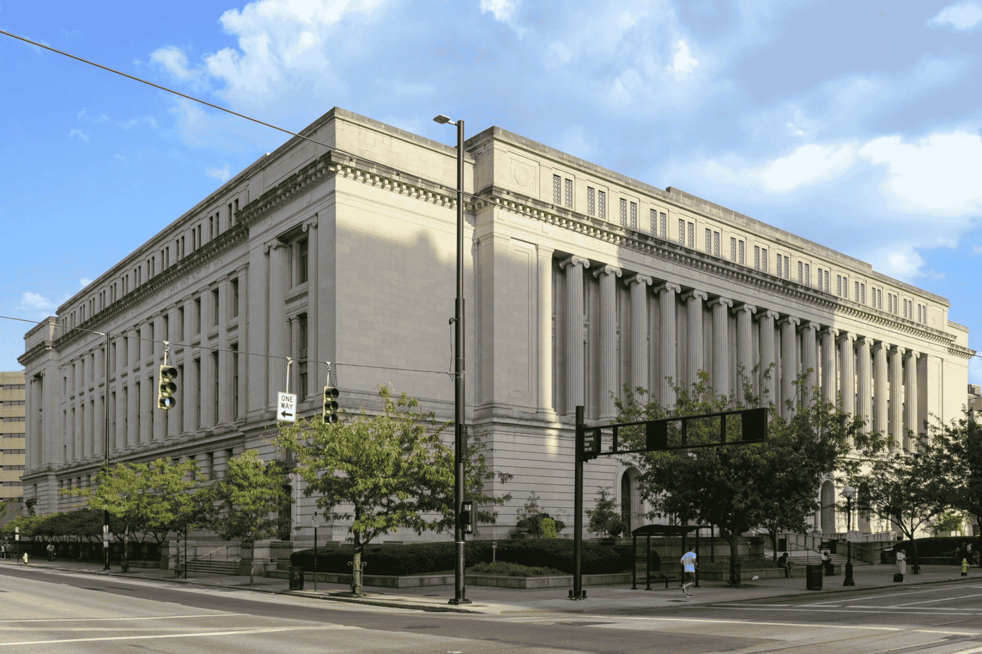 Exterior view of the Hamilton County Courthouse in Cincinnati, Ohio, showing the limestone building and columns under a blue sky.