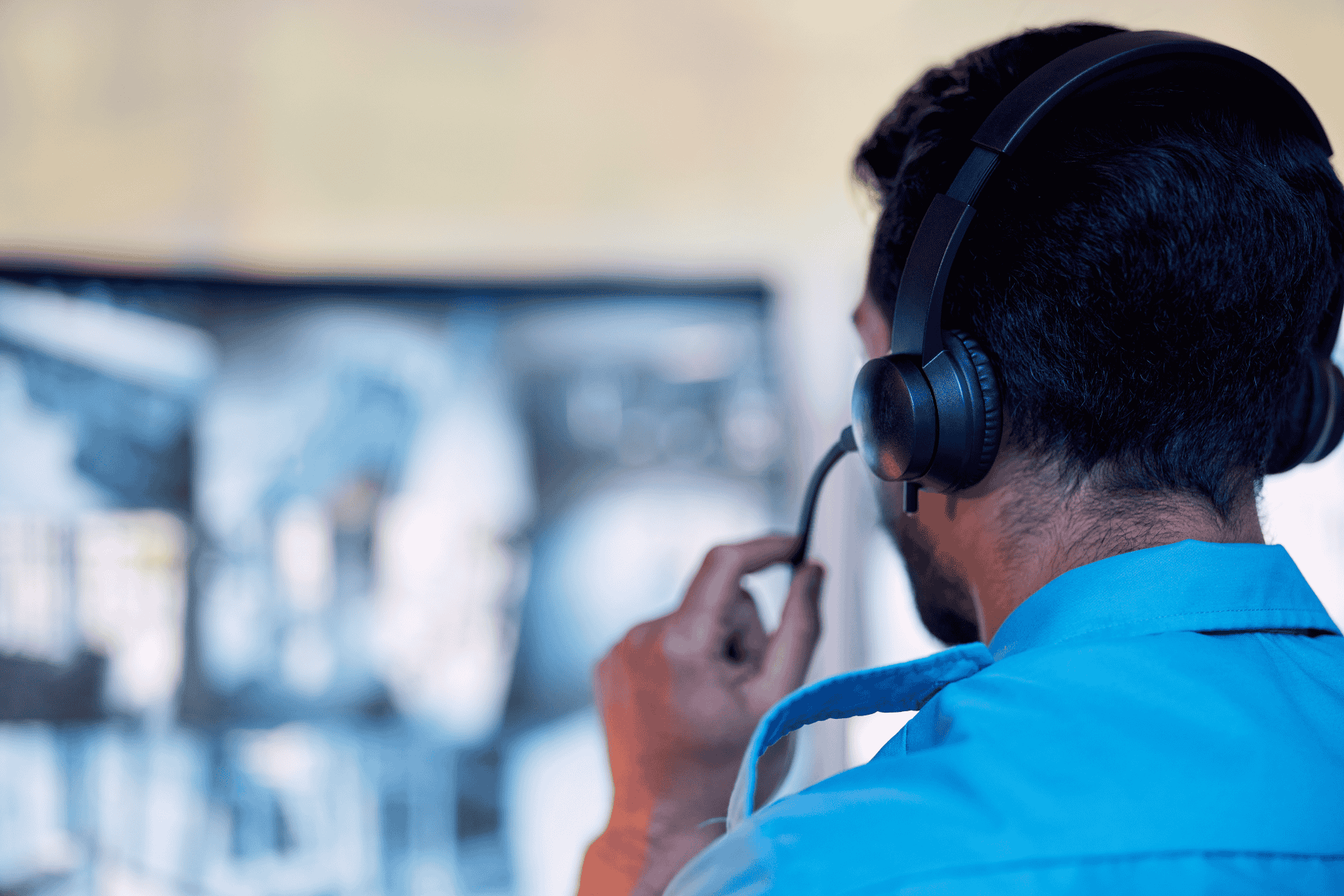 Photo represents a Hamilton County EMA staff member wearing a headset and monitoring screens at the emergency operations center Springdale.