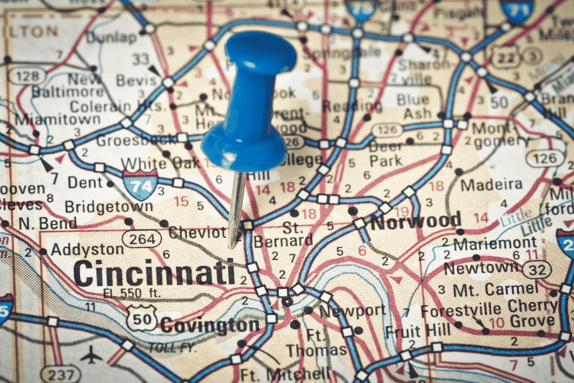 Close-up road map of Cincinnati, Ohio, with a blue pushpin marking the city center and showing surrounding suburbs like Norwood and Covington.