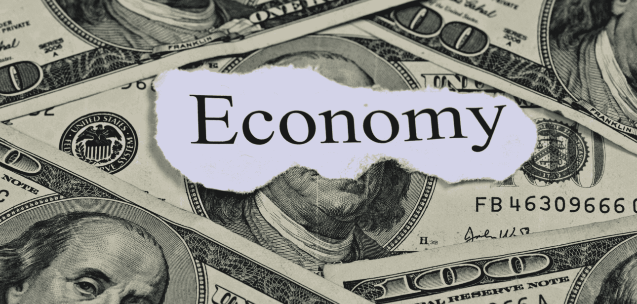 A collage of US dollar bills with the word "Economy" printed on a torn piece of paper in the center.