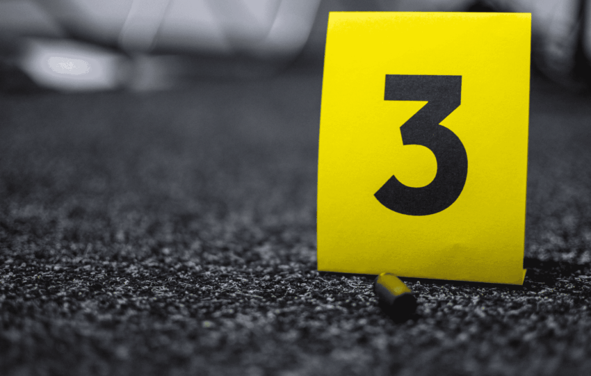 Yellow evidence marker labeled with the number 3 on dark asphalt.