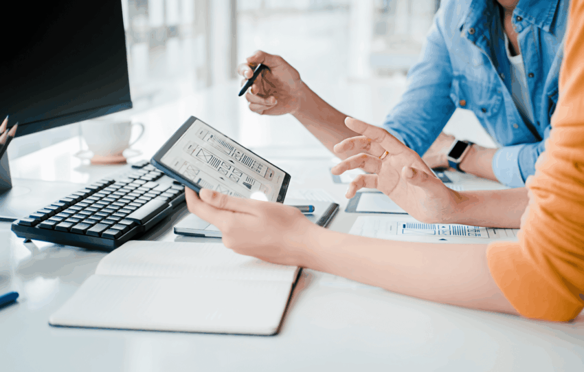 Two professionals collaborating over a digital tablet in a modern Cincinnati office setting, representing the city's growing startup ecosystem.
