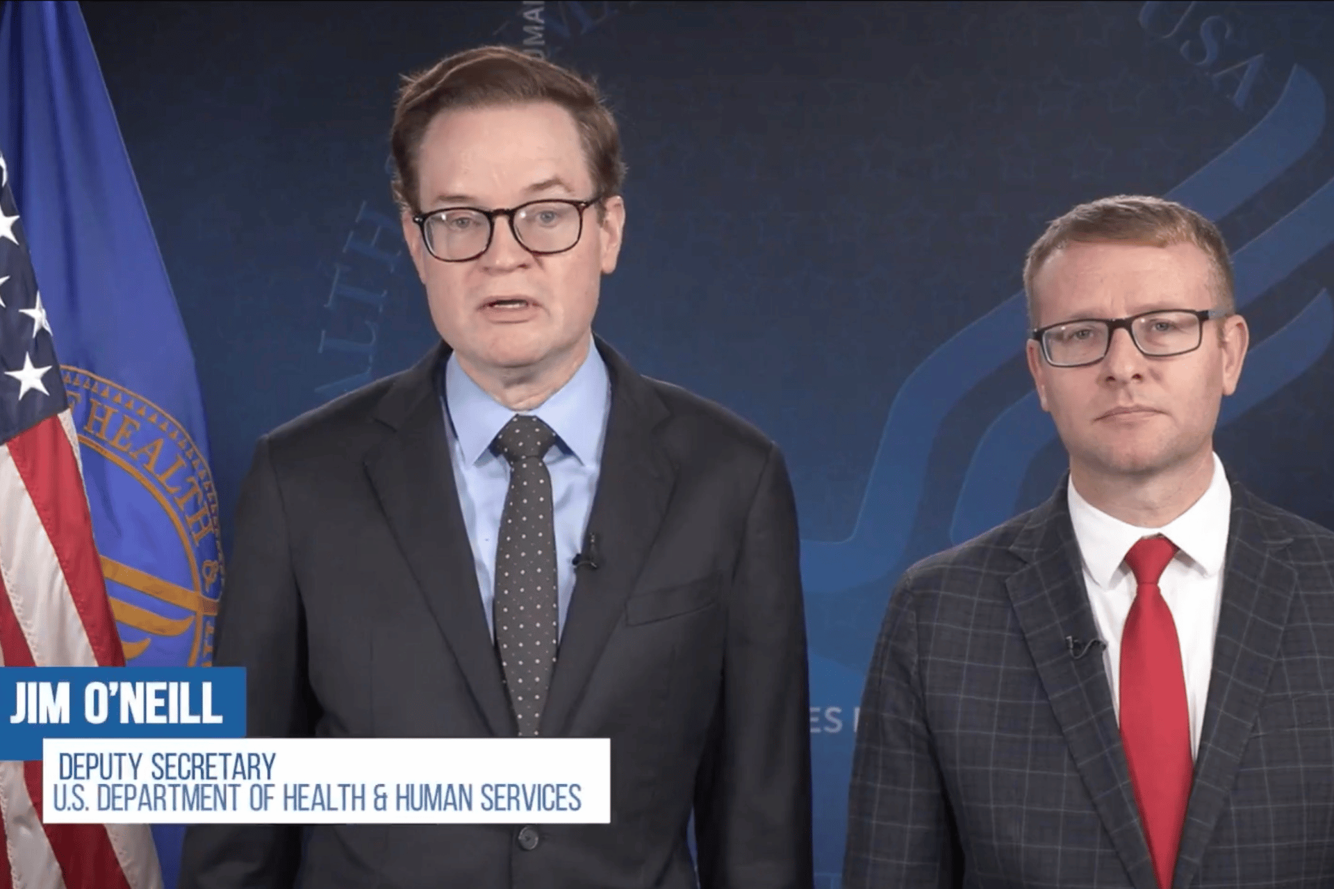 U.S. HHS Deputy Secretary Jim O'Neill on the left and a man in a suit with glasses on the right.