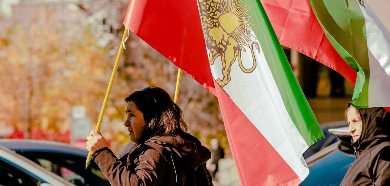 Iran protesters hold flags during nationwide demonstrations as the Iran protests death toll surpasses 300