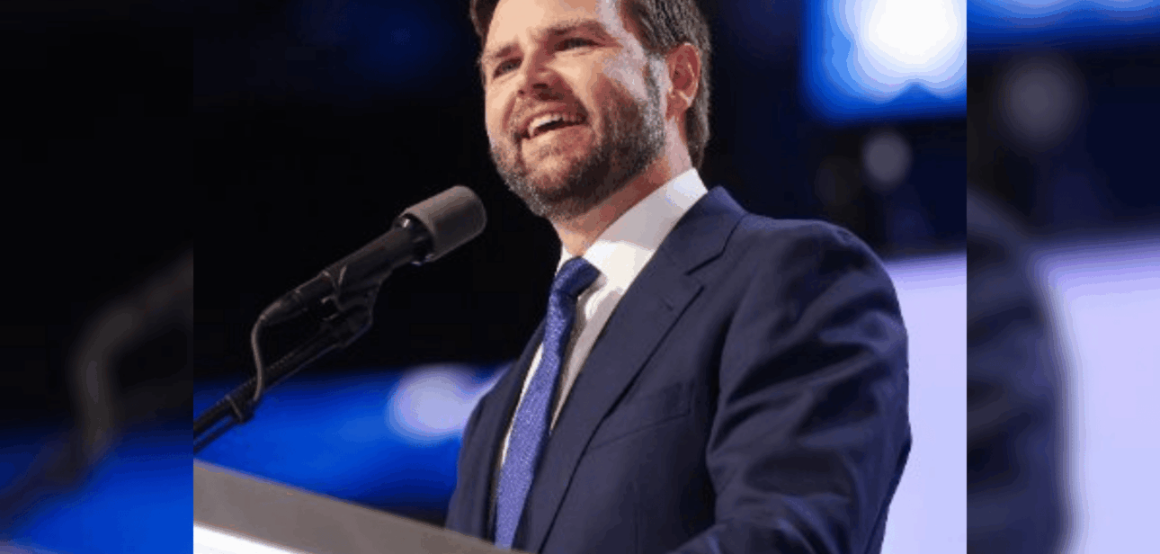 JD Vance speaking at a podium. Reports indicate windows were broken at his Cincinnati home in a vandalism incident on January 5, 2026.