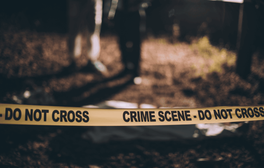 Crime scene tape in a dimly lit area representing the 2025 murder rate statistics in the United States.
