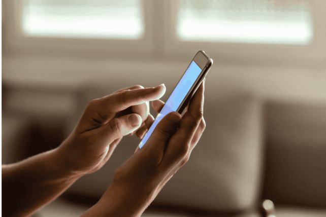 Student holding a smartphone, illustrating the upcoming Ohio cellphone ban in schools policy.