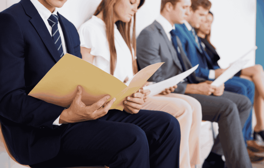 Job applicants sitting in a row waiting for interviews, illustrating current Ohio job market trends.