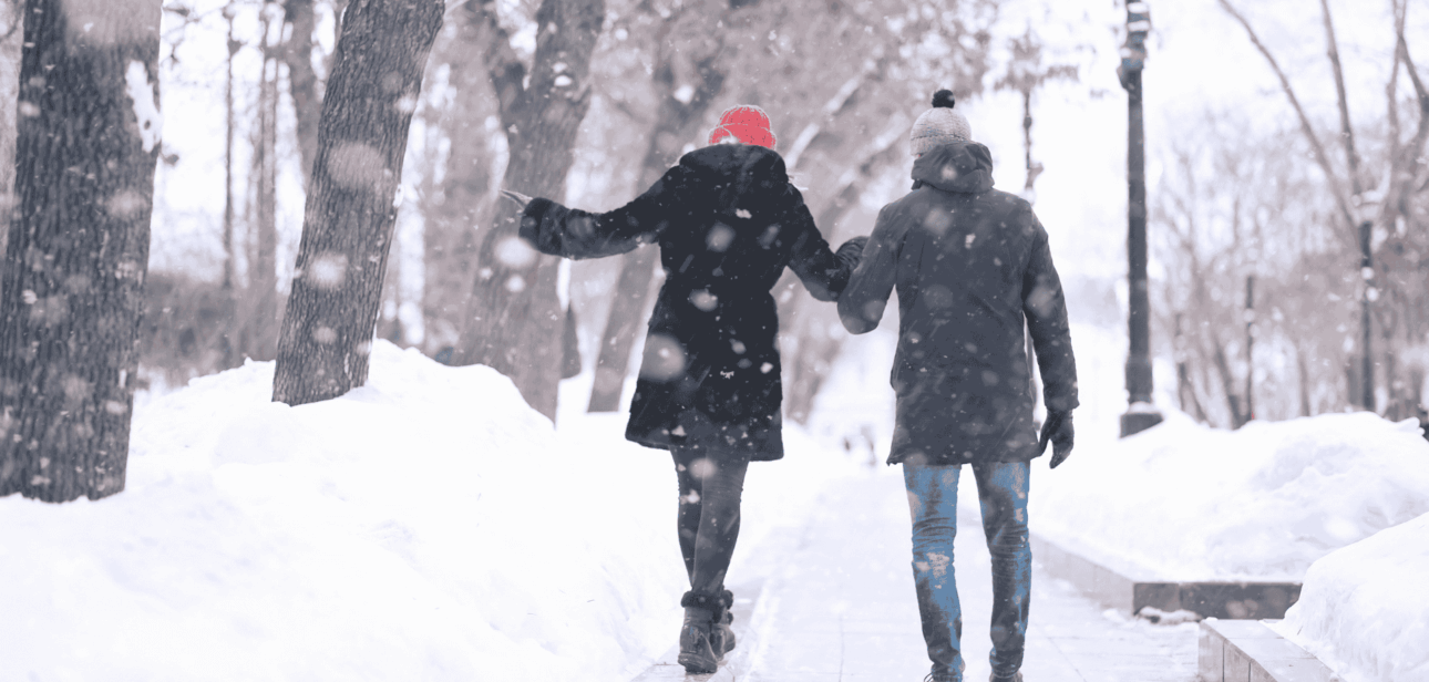 Two people walking on a snow-covered path during a winter storm in Cincinnati.