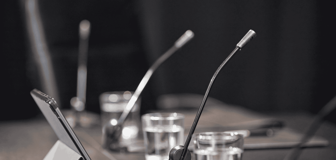Microphones on a conference table representing secret settlement concerns within Cincinnati City Council.