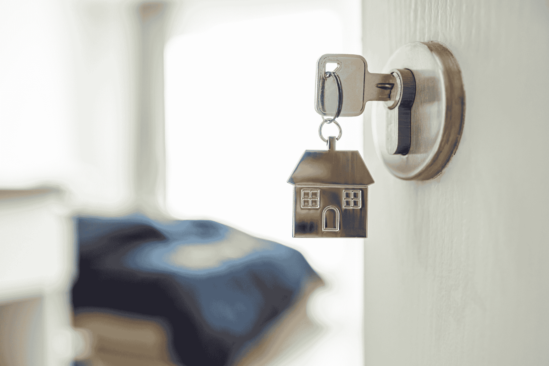 A key in a door lock with a house-shaped keychain, illustrating short-term rental safety and security in Ohio.