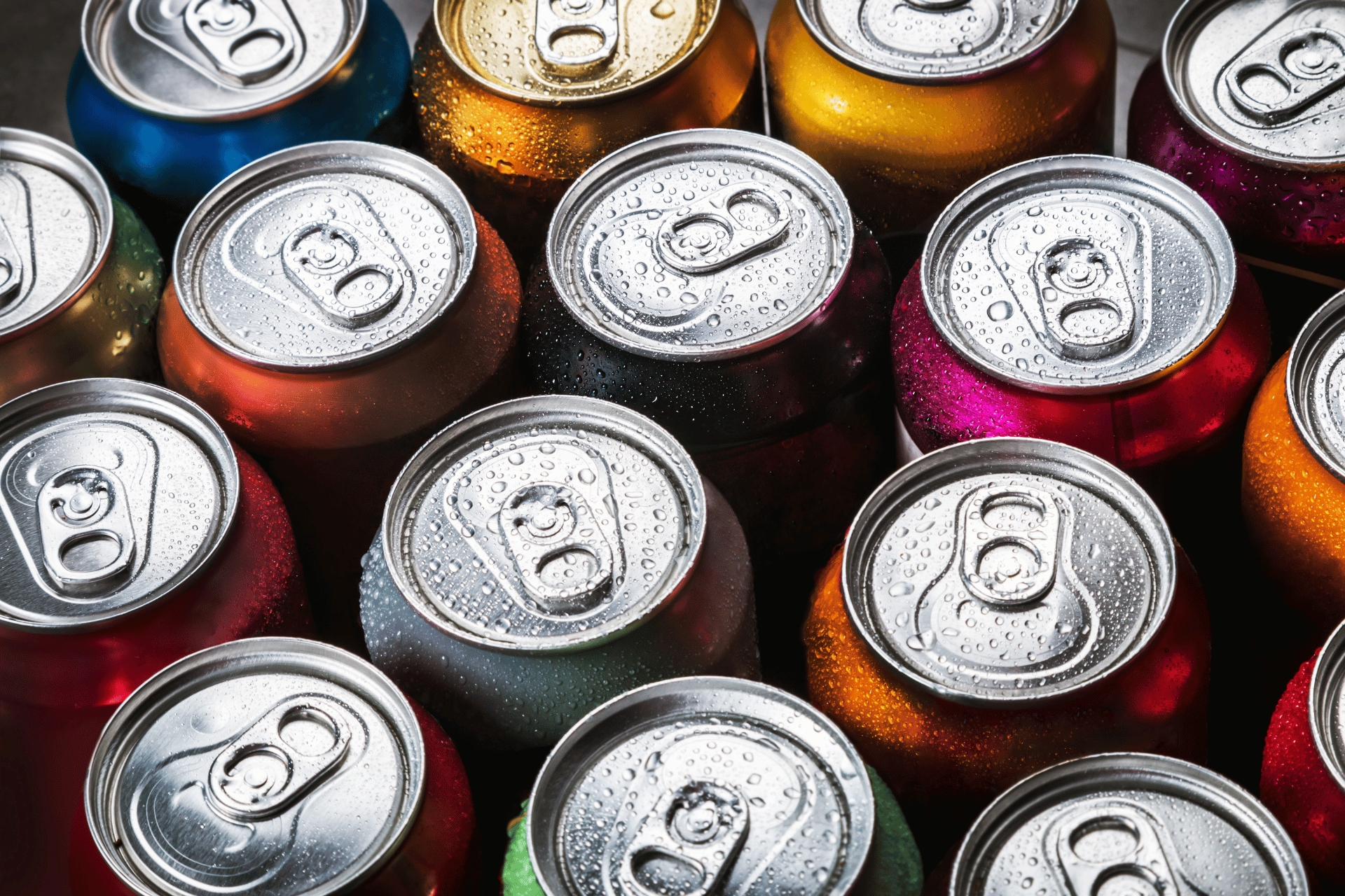 A top-down view of several colorful soda cans grouped together, illustrating sugar-sweetened beverages subject to SNAP ban proposals.