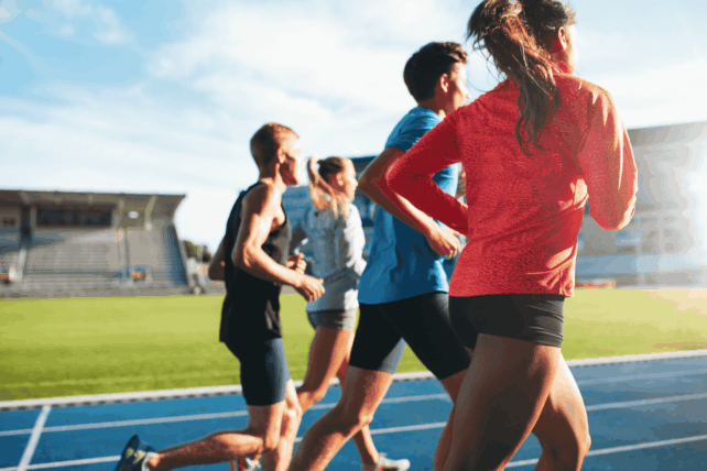 Group of athletes running on an outdoor track, illustrating the debate over transgender athlete bans reaching the U.S. Supreme Court.