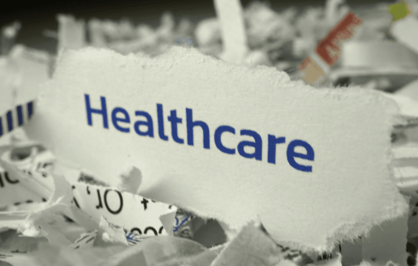Concept image for the TriHealth UnitedHealthcare agreement showing the word Healthcare on shredded paper.