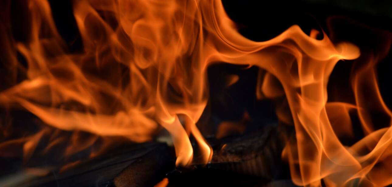 Close-up of bright orange flames burning against a dark background.