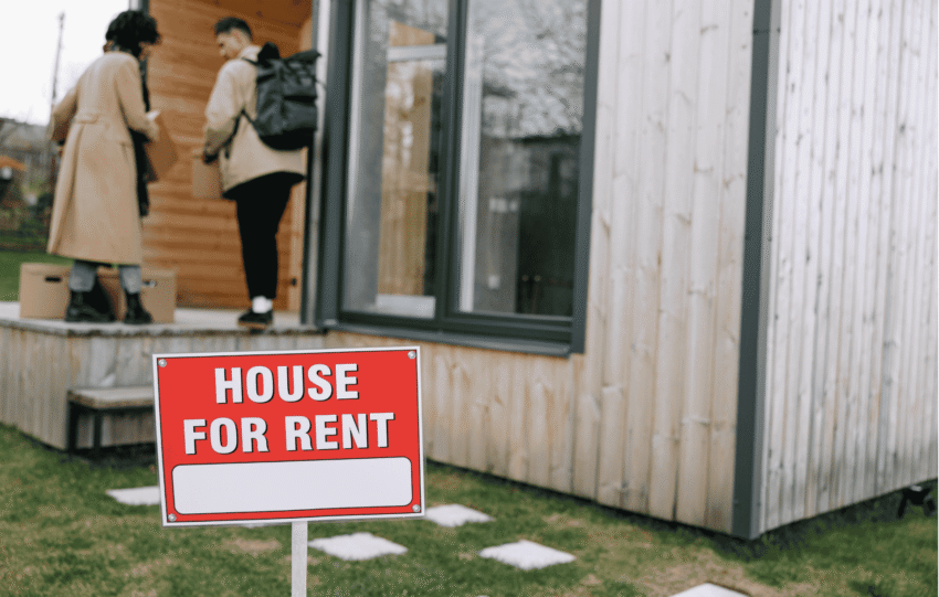 Two people looking at a modern house with a "For Rent" sign in the yard, illustrating the Cincinnati housing shortage and rental market trends.