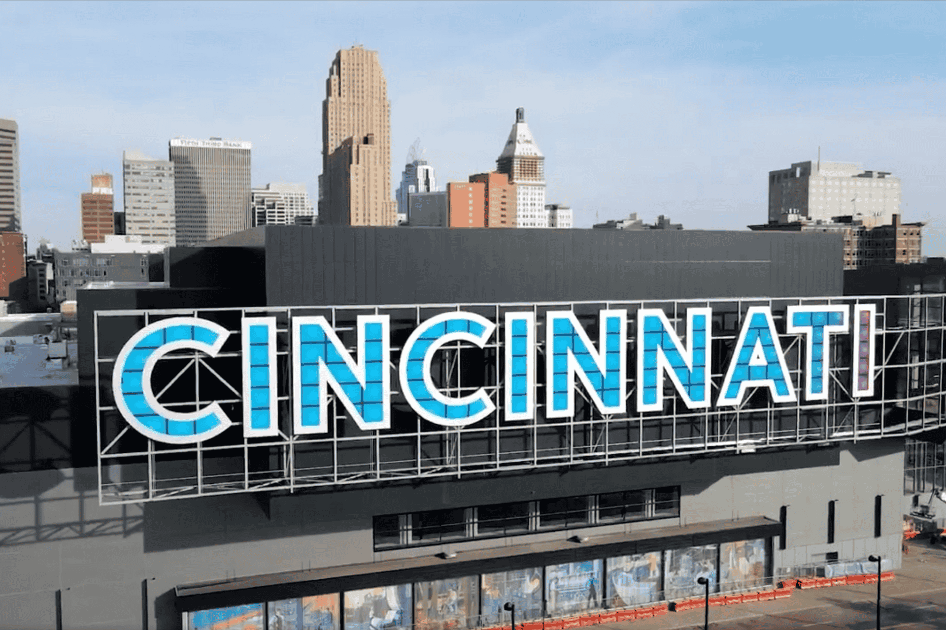 The large CINCINNATI sign on the side of the Duke Energy Convention Center with the First Financial Center skyscraper rising in the background.