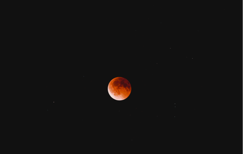 A total lunar eclipse, also known as a blood moon, glowing deep red against a dark night sky.