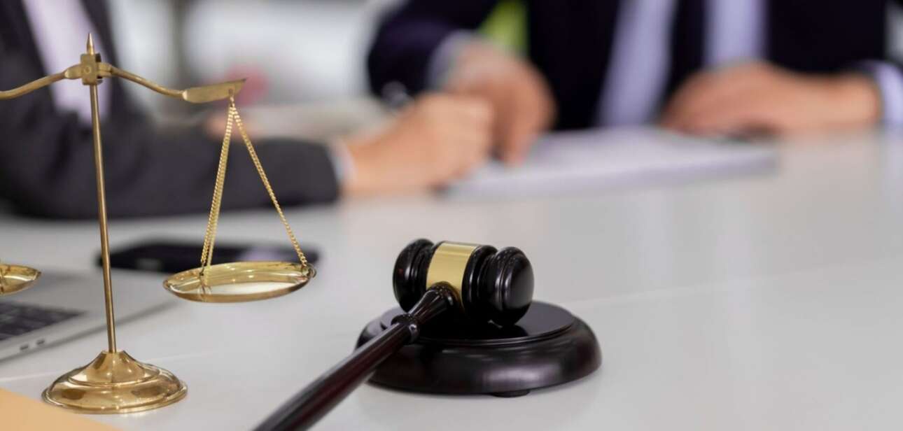 A wooden gavel and brass scales of justice on a courtroom desk, used as a featured image for news coverage of the Afroman lawsuit verdict in Adams County.