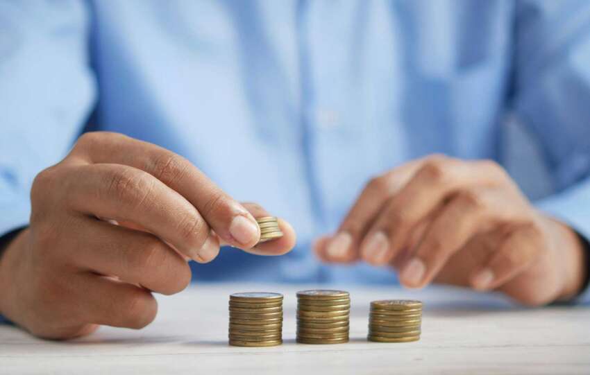 Hands stacking coins to represent rising Cincinnati income tax and financial decision-making