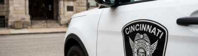 Close-up of a Cincinnati Police patrol cruiser parked on a city street, representing the department currently evaluating proposed police budget cuts.